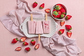Strawberry ice cream popsicles with fresh strawberries