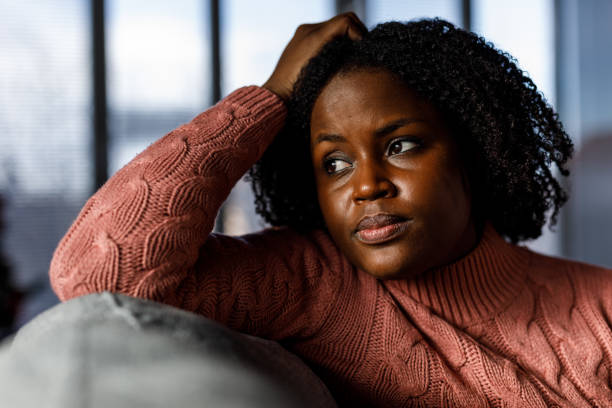 istock Anxious young woman sitting on the sofa, looking away, worrying 1498953380