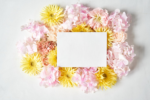 white card for text. Petals of flowers, carnation, gerbera, hydrangea, rose. Valentine's day romantic background . Space for words. Love letter. High quality photo
