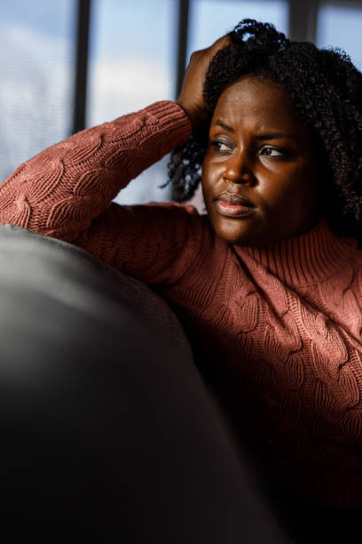 istock Anxious young woman sitting on the sofa, looking away, worrying 1498954572