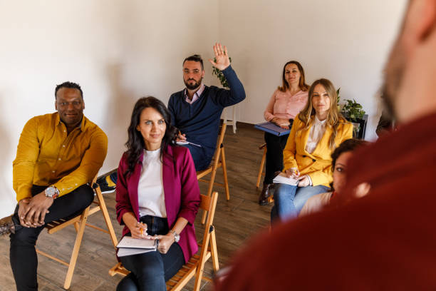 istock Man raising his hand to ask a question during a conference or a seminar 1498954992
