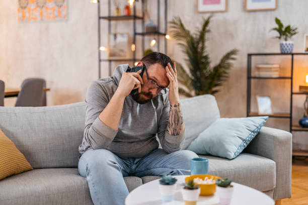 istock Worried Man Talking On The Phone At Home 1498955753