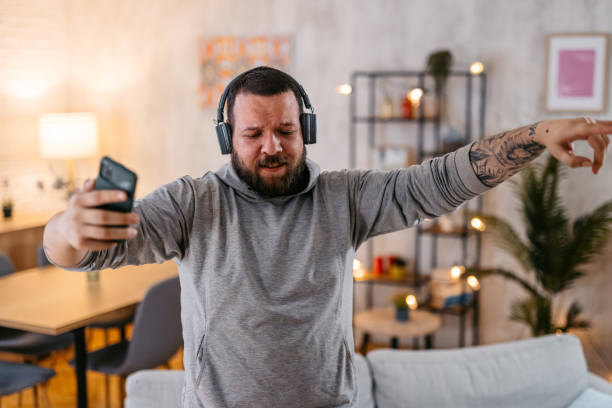 istock Man Listening To Music On Headphones While Singing And Dancing 1498955837