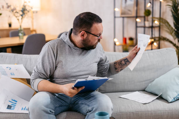 istock Young Man Checking His Finances At Home 1498957968