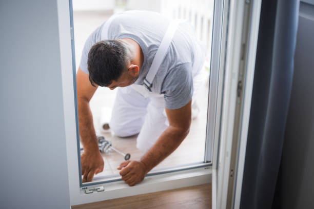 istock Handyman fixing balcony door with silicone gun when 1498958091