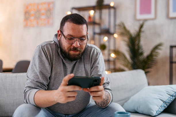 istock Young Man Watching Content On His Phone 1498958636