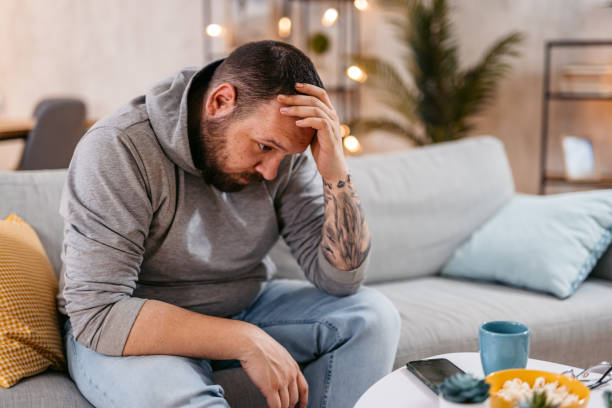 istock Stressed Man Sitting Alone Holding His Head 1498960295