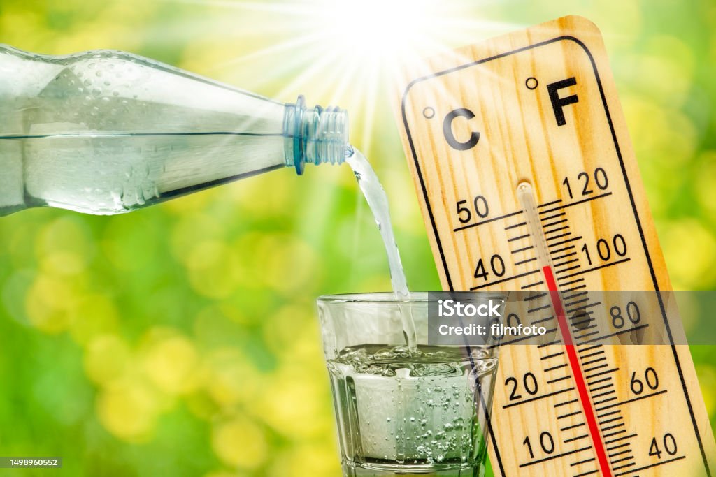 thermometer shows high temperature in summer heat and bottle with water with drinking glass Heat - Temperature Stock Photo