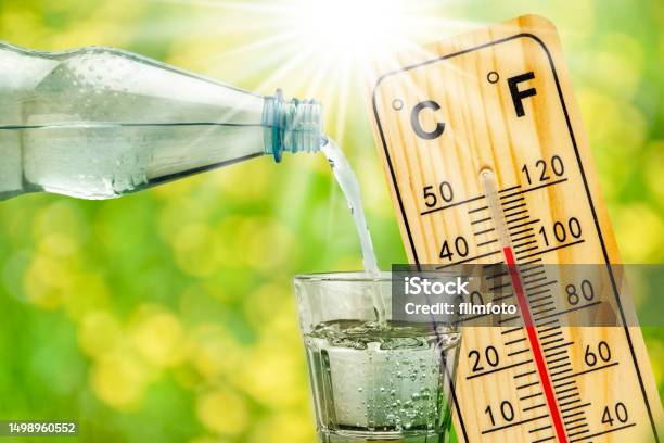 Thermometer Shows High Temperature In Summer Heat And Bottle With Water With Drinking Glass Stock Photo - Download Image Now