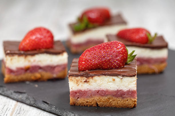 A piece of chocolate and vanilla cake with strawberries stock photo