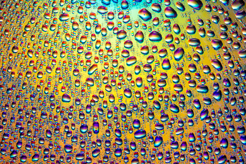 Droplets of Water over a Yellowish Gradient Reflective Surface With Double Reflections