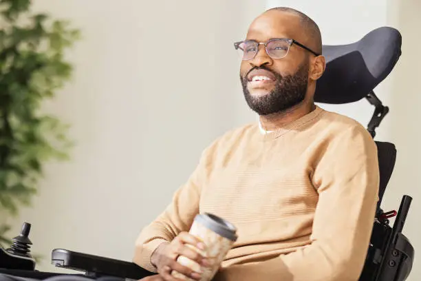 Photo of Disabled Black Man Using Smartphone at Home