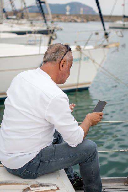 istock Handsome man using mobile phone to sailing boat 1498978900