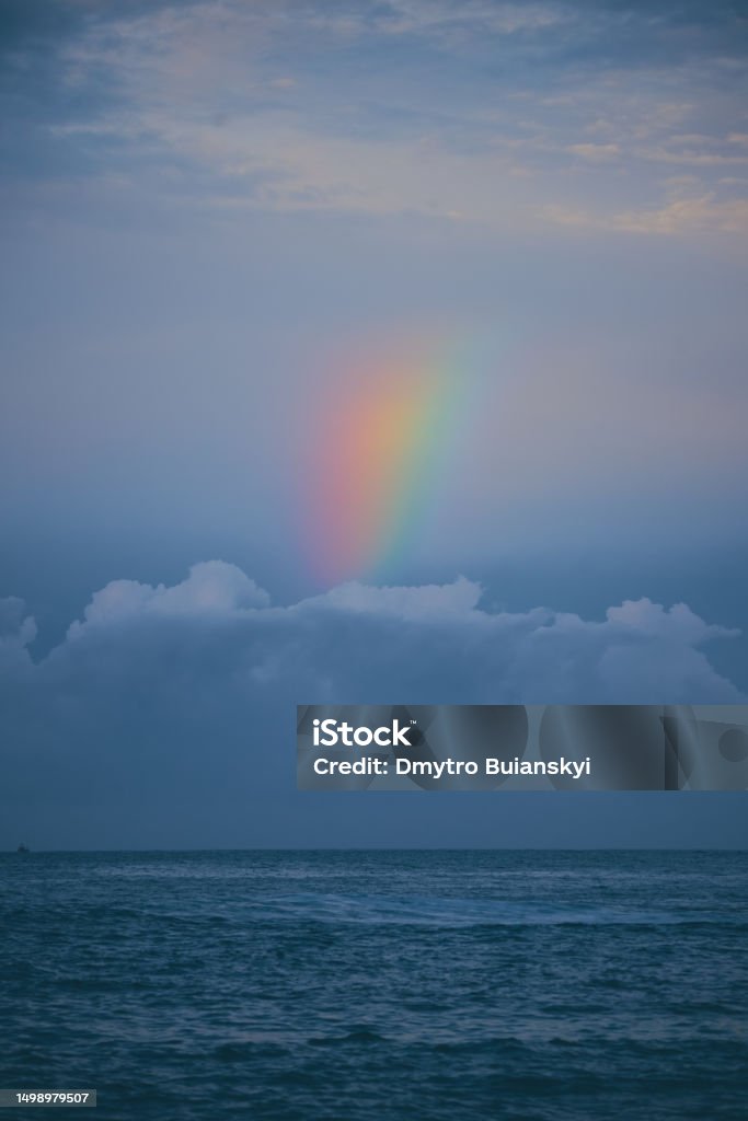 Rainbow Over the Sea Calm Water in the Evening after Raine Beautiful backdrop with the turquoise sea with a rainbow at sunset. High-quality photo Abstract Stock Photo