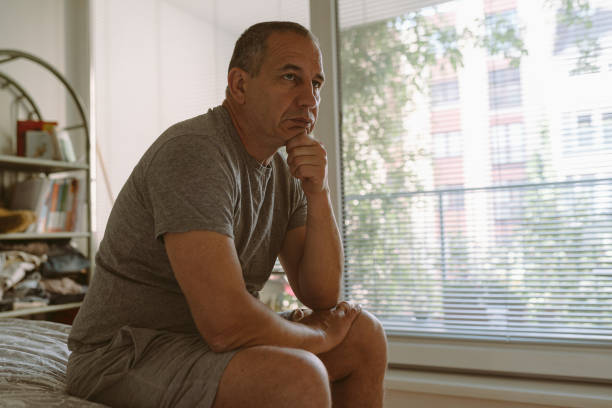 istock Middle-aged man in bedroom sitting on bed 1498979564
