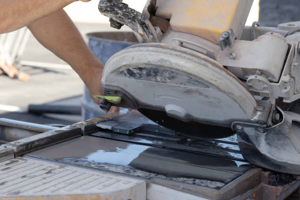 Working on a wet saw machine using a diamond blade to cut ceramic tile