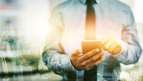 Phone, hands and overlay of business man texting, web scrolling or internet browsing. Technology, city double exposure and male employee networking, research or social media on 5g smartphone at night