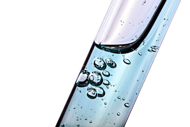 Test tube with transparent liquid and bubbles isolated on white background. Macro.