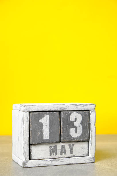 istock May 13 calendar made wooden cubes yellow background.With an empty space for your text. 1498986432