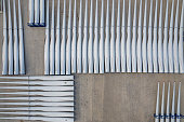 Aerial view of the blade parts of a wind turbine parked on a cement yard