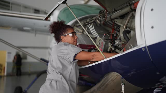 Airplane mechanic repairing a airplane engine in the airport hangar