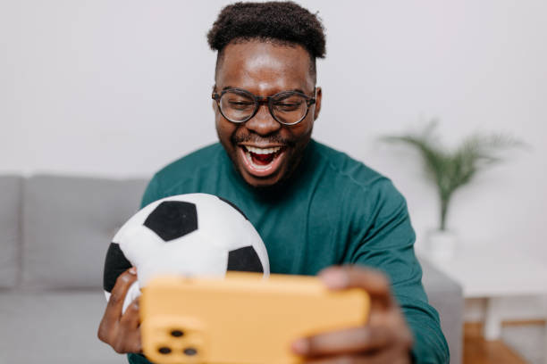Man Embraces Game, Ball at His Side for Immersive Experience