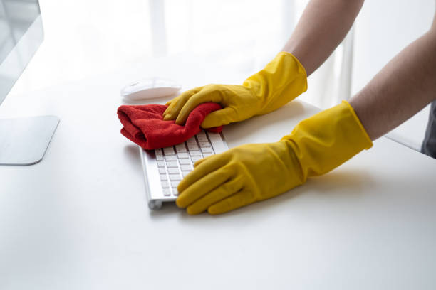 istock Close up view of man cleaning keyboard computer using clothes. Cleaning office desk concept. 1499001477