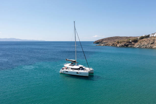 Sailing boat catamaran on rippled sea, rocky shore, summer vacation, Greek island Greece stock photo