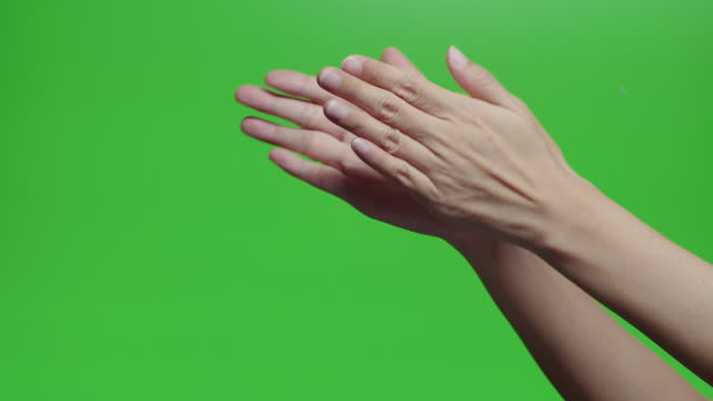 Asian woman clapping hands or applauding on chroma key green screen. Meaning for good or admire celebrate. Human body part gesture isolated on green screen concept.