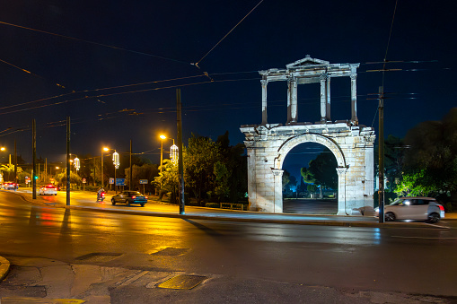 Evening view of an illuminated ancient Arch of Hadrian, most commonly known in Greek as Hadrian's Gate in the historic center of Athens, Greece.