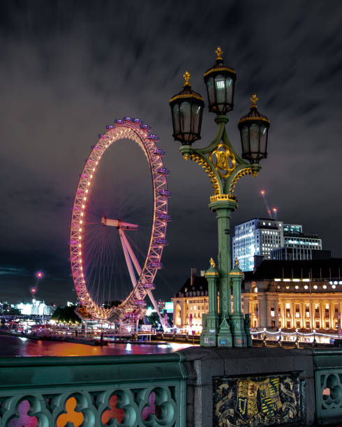 Views in London, United Kingdom in spring time Night time over the Thames River at night time with the London Eye in view lit up with lights. thames valley stock pictures, royalty-free photos & images