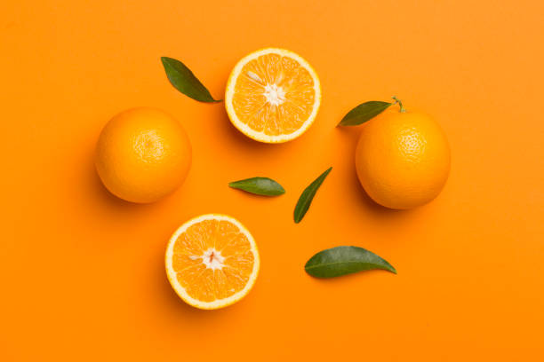 istock Flat lay with fresh oranges and leaves on color background 1499016725