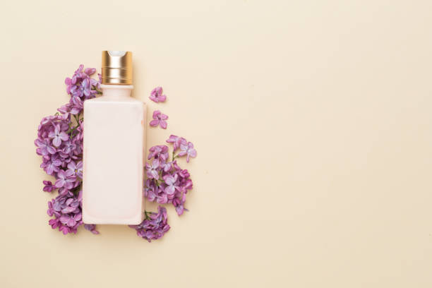 istock Composition with cosmetic bottle and flowers on color background, top view 1499018799