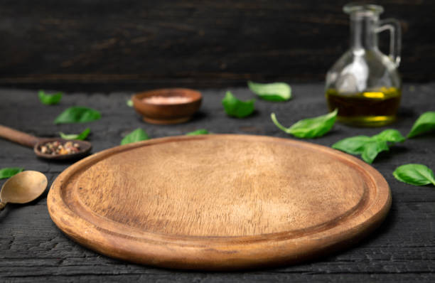 istock Empty board for pizza on wooden table with spices 1499019551
