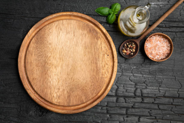 istock Empty board for pizza on wooden table with spices 1499019566