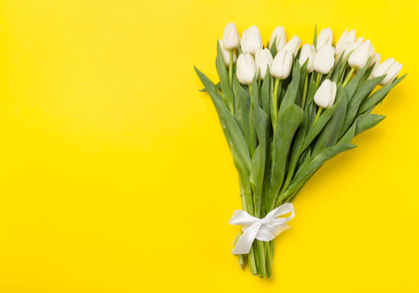 istock White tulip bouquet on color background, top view 1499022779