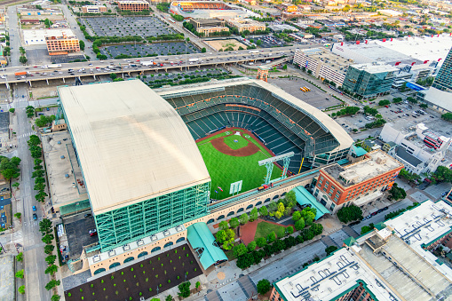 Houston, United States - April 13, 2023:  Minute Maid Park with the roof retracted; the home of Major League Baseball's Houston Astros located in downtown Houston, Texas shot from an altitude of about 500 feet at sunset.