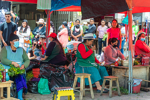Cuenca, Ecuador - January 13, 2023: Market Rotary Plaza in Cuenca. Rural women practice alternative medicine using natural elements such as plants, chicken eggs, worms, artisanal liquor, etc.