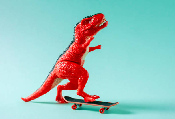 istock Red toy dinosaur skateboarding on blue background. 1499028604