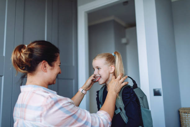 istock Mother helping her daughter to put on backpack for school 1499031327
