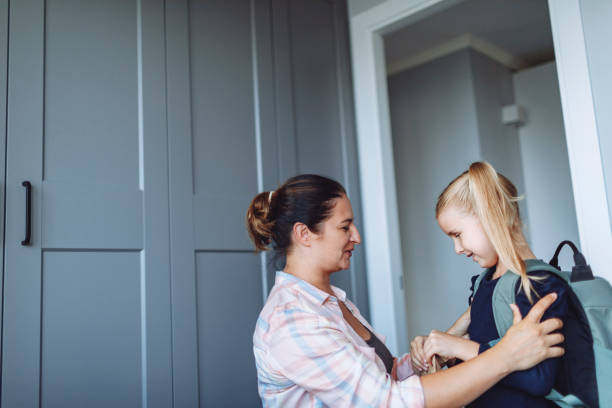 istock Mother helping her daughter to put on backpack for school 1499031513