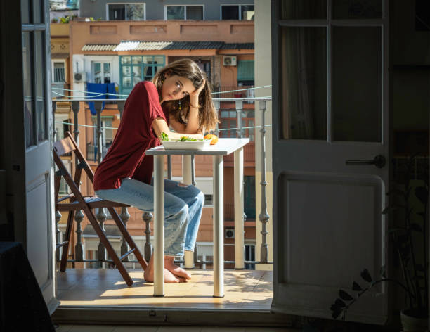 istock Young woman looking at camera after dinner in the balcony 1499031542