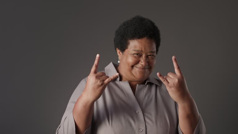 Portrait of Senior African American Woman Making Rock Sign