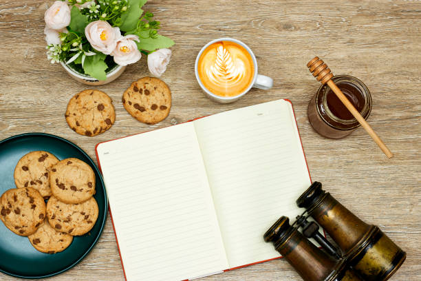 istock latte art coffee and cookies and honey, empty notebook on notebook with old binocular 1499036917