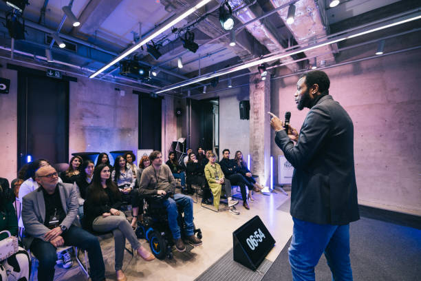 Entrepreneur giving a presentation for a diverse audience at conference stock photo