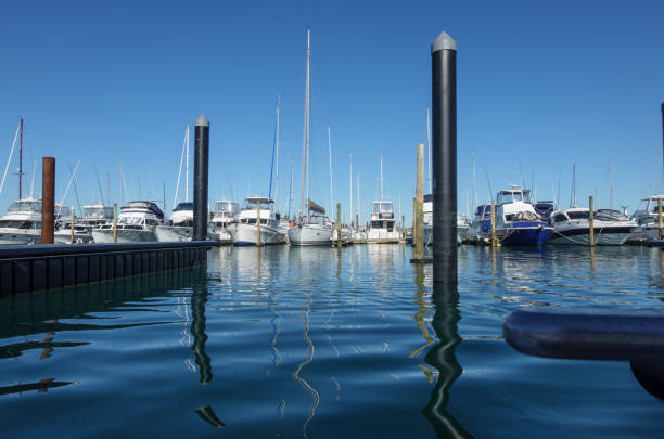 istock Marina pilings reflected in blue water with moored luxury boats 1499039711