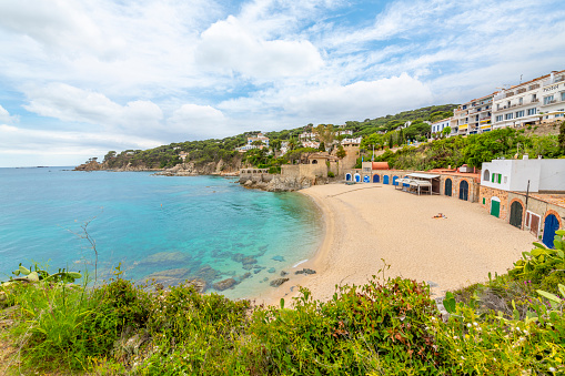 A stretch of sandy beach along a small bay on the Mediterranean Sea on the Costa Brava coast at the village of Calella de Palafrugell, Spain.