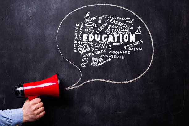 Man holding red loudspeaker in front of a blackboard. There is a hand drawn message bubble.