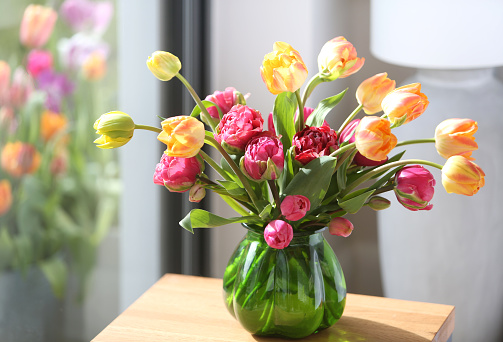 Colorful bouquet of tulips on blue wooden background. Spring tulip flowers. Greeting card with copy space for Valentine's Day, Woman's Day and Mother's Day.