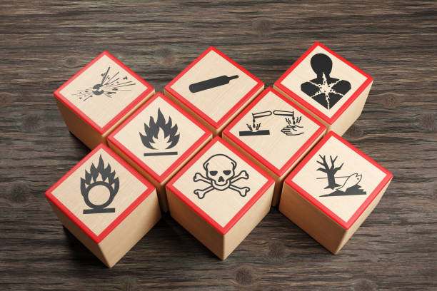 деревянные блоки с различными символами предупреждений о химической опасности на деревянном столе. иллюстрация концепции токсичных вещес - hazardous materials protection стоковые фото и изображения
